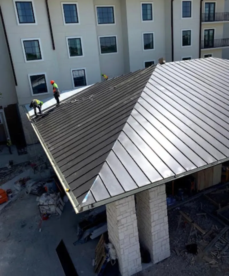 Crew installing standing seam metal roof panels on a commercial project in Mineral Wells
